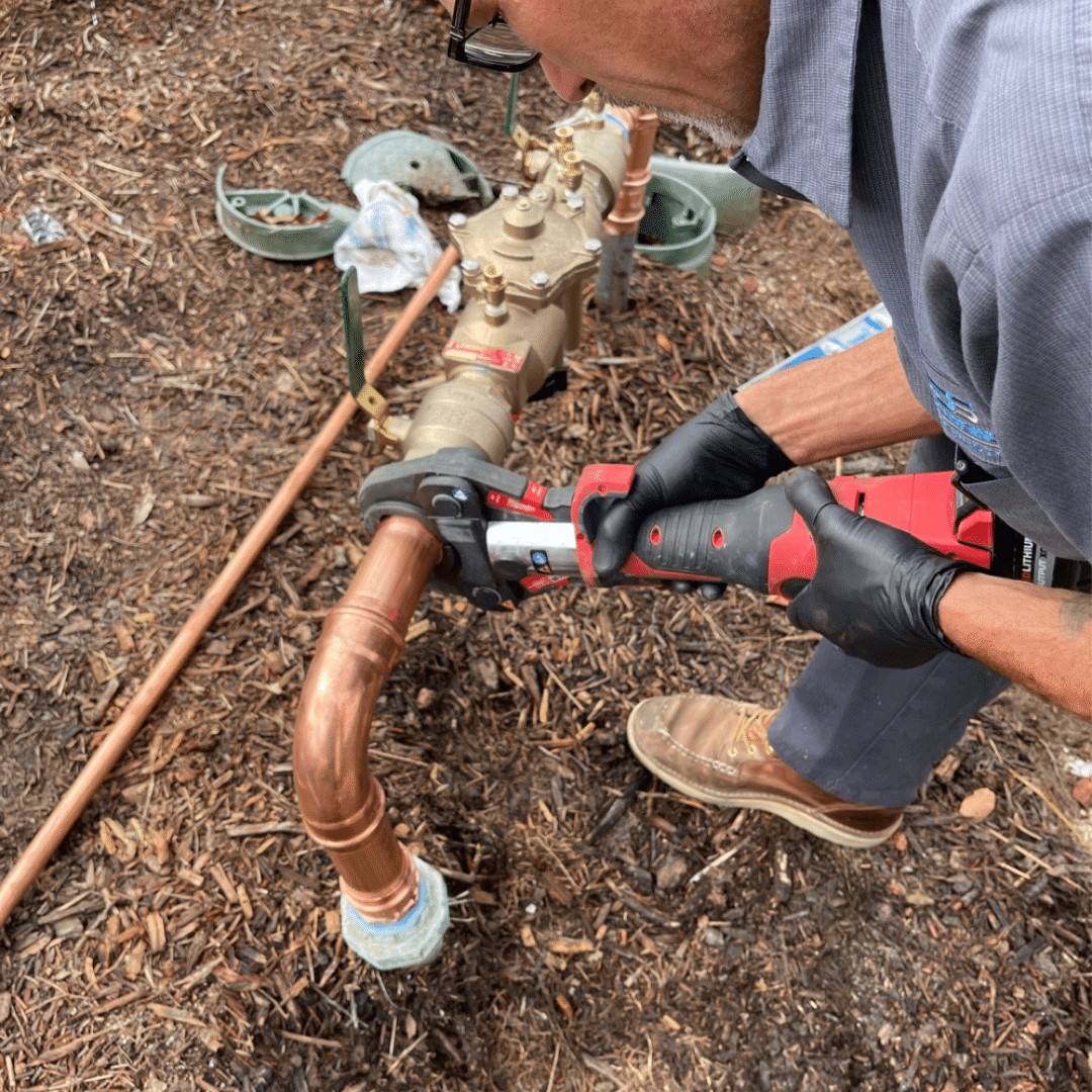 Plumber with wrench working on Backflow Preventer